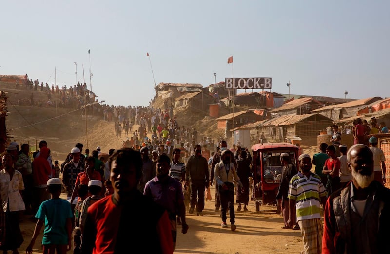 FILE - In this Jan. 28, 2018, file photo, Rohingya refugees come out of their homes after the visit of Indonesian President Joko "Jokowi" Widodo at Jamtoli refugee camp near Cox's Bazar, Bangladesh. Authorities in Bangladesh said Tuesday, Oct. 22, 2019, that they want to start relocating thousands of Rohingya refugees to a Bay of Bengal island soon from crammed camps near the border with Myanmar, from where they fled. Top government administrator in Cox's Bazar, Kamal Hossain, said they listed 100 families willing to move to Bhasan Char, an island hours by boat from the mainland. The government has said it will relocate 100,000 refugees to the island in phases. (AP Photo/Manish Swarup, File)