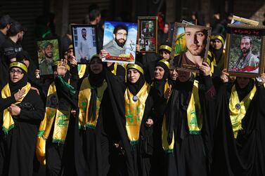 hezbollah women supporters march in Beirut holding pictures of  relatives who were killed fighting in Syria  October 1, 2017.  AFP