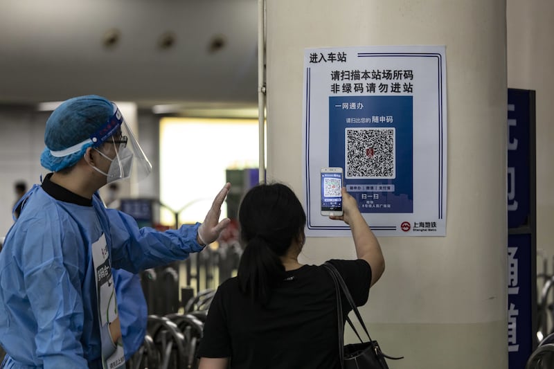 A woman scans a tracking QR code at a subway station. Bloomberg