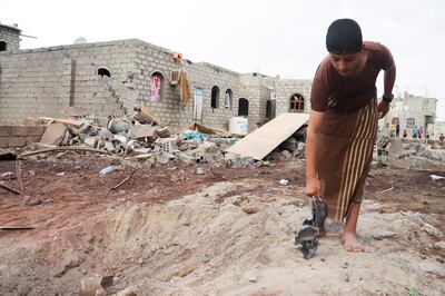 A boy holds shrapnel of a missile at the site of a Houthi missile attack in north-east Yemeni province of Marib on October 3, 2021.  Reuters