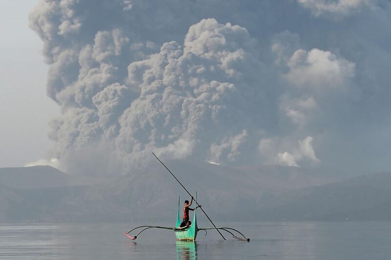 A man in a canoe on Lake Taal as its volcano spews ash in Batangas, south of Manila.  AFP
