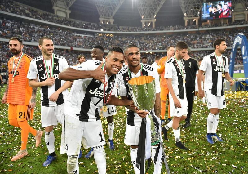 Juventus players carry around the Italian Super Cup on a lap of honour.  EPA