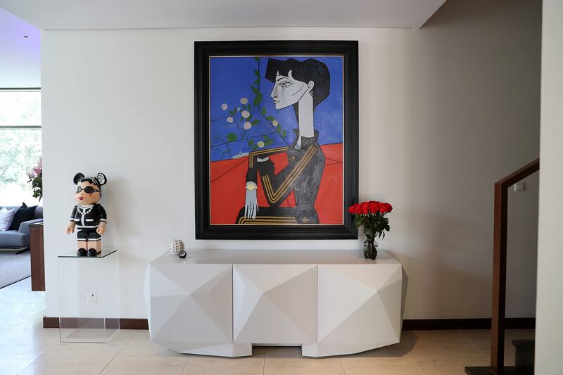 A Bearbrick doll is positioned adjacent to an original Ross Muir painting.