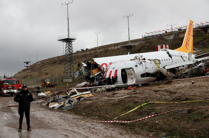 A Police officer stands guard near the Pegasus Airlines Boeing 737-86J plane wreckage, after it overran the runway during landing and crashed, at Istanbul's Sabiha Gokcen airport, Turkey February 6, 2020. REUTERS/Murad Sezer