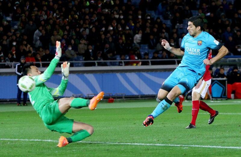 Luis Suarez, right, kicks the ball past Guangzhou Evergrande’s goalkeeper Li Shuai to score. Eugene Hoshiko / AP Photo