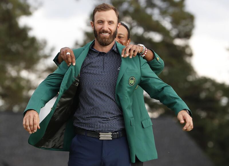 Dustin Johnson is presented with his green jacket by defending champion Tiger Woods after winning the Masters at the Augusta National Golf Club on Sunday, November 15. EPA