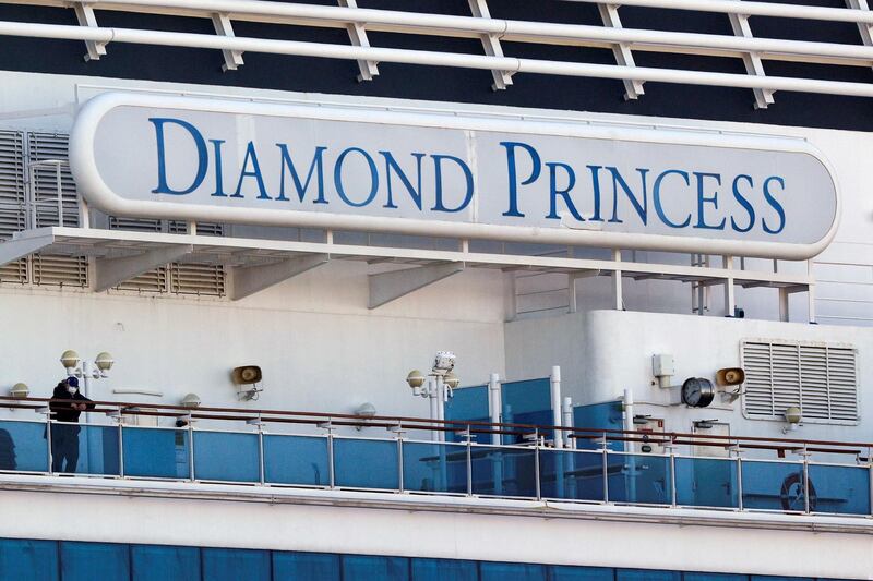 A passenger wearing a mask stands on the deck of the cruise ship Diamond Princess. Reuters