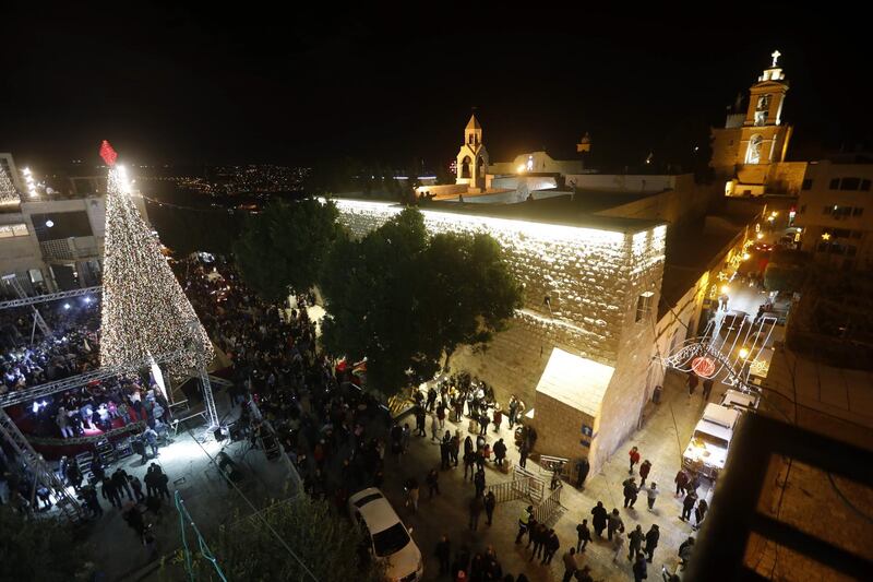 A crowd attends the ceremony of lighting the Christmas tree of the Nativity Church in the West Bank city of Bethlehem.  EPA