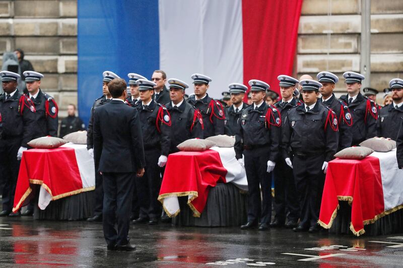 epa07905233 French President Emmanuel Macron stands by coffins during a ceremony to pay tribute to the victims of the 03 October knife attack in Paris' Police headquarters, in Paris, France, 08 October 2019. Four officers were killed in a knife attack by Police employee Mickael Harpon on 03 October.  EPA/IAN LANGSDON
