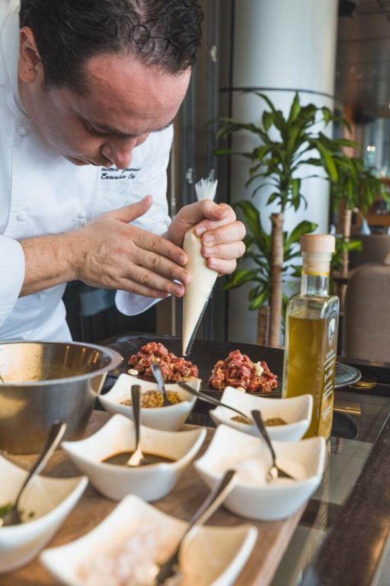 Head chef Francesco Guarracino prepares the Wagyu beef tartare in front of guests at Roberto's Abu Dhabi. Courtesy Roberto's Abu Dhabi