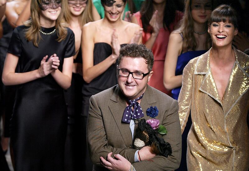 (FILES) In this file photo taken on October 12, 2003 designer Alber Elbaz acknowledges the audience alongside Canadian supermodel Linda Evangelista, (R) after his show for Lanvin 12 in Paris during the ready-to-wear Spring/Summer 2004 collections. Alber Elbaz, the fashion designer whose audacious billowing designs transformed the storied French house Lanvin into an industry darling before his shock ouster in 2015, has died aged 59, the Richemont luxury group said on April 25, 2021.     / AFP / JEAN-PIERRE MULLER
