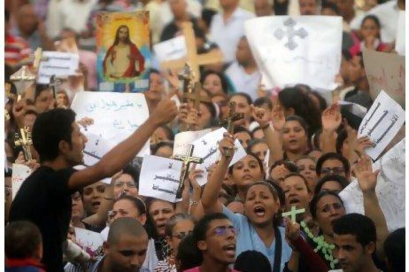 Coptic Christians hold crosses and shout slogans during a protest in Cairo yesterday at the destruction of a church in the southern Egyptian province of Aswan.