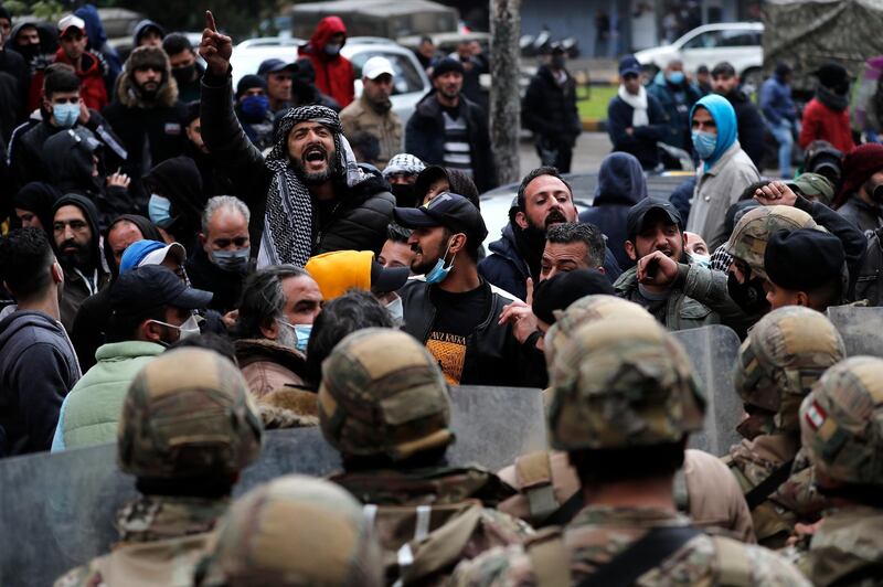 Protesters shout slogans in front of Lebanese soldiers in Tripoli. AP