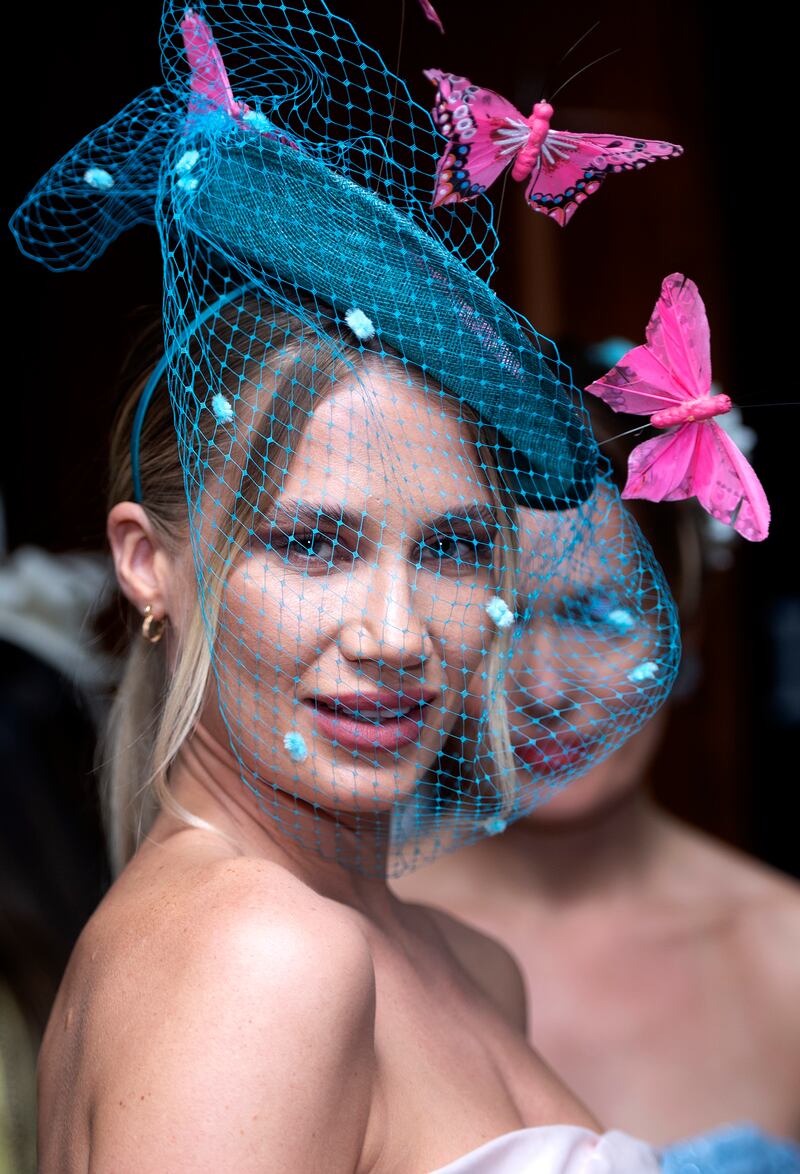 Butterflies sit atop the netting of this green-blue fascinator. AP Photo