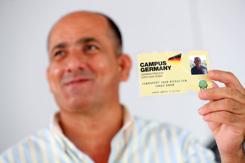 Aziz holds a special ticket that staff at the Germany pavilion made for him