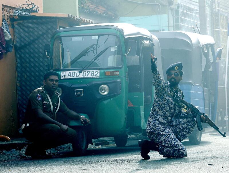 Security personnel react as a device is detonated in a controlled explosion in a van near St Anthony's Church. EPA