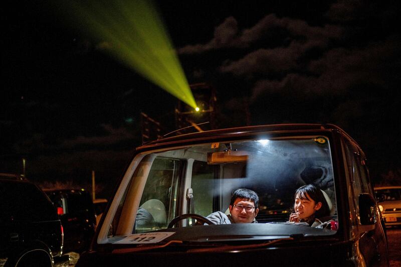 Visitors sit inside their cars at a drive-in cinema at Nagai Seaside Park in Yokosuka, Kanagawa prefecture, south of Tokyo. AFP