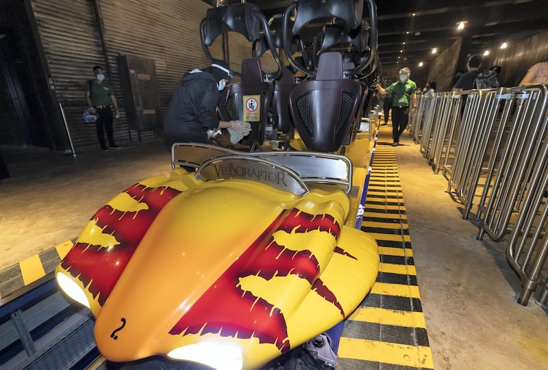 Dubai, United Arab Emirates - Reporter: N/A. Covid-19/Coronavirus. A member of staff cleans the Velociraptor after visitors ride it. IMG World of Adventure opened on recently to the public with strict Covid-19/Coronavirus safety measures. Tuesday, July 21st, 2020. Dubai. Chris Whiteoak / The National