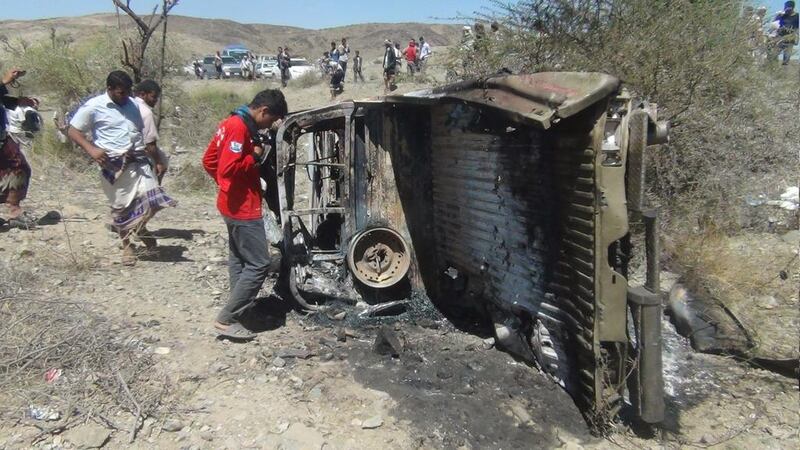 People inspect the wreckage of a car hit by an air strike in the central Yemeni province of Al Bayda on April 19. Reuters