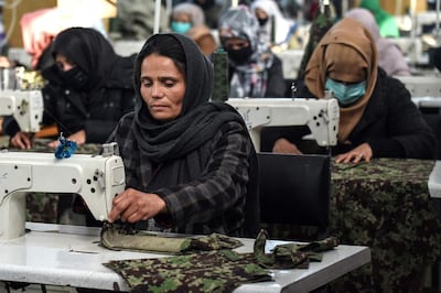 In this photograph taken on February 8, 2021, women who lost their husband or relatives in the ongoing war in Afghanistan with the Taliban stitch military uniforms at a factory in Kabul. Dozens of women widowed by the Afghan war have been given a lifeline by the army, stitching military uniforms indistinguishable from the ones their husbands died in. / AFP / WAKIL KOHSAR
