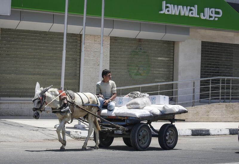 A Palestinian rides a donkey-pulled cart carrying sacks of food aid provided by the United Nations Relief and Works Agency for Palestine refugees (UNRWA) in the town of Rafah, in the southern Gaza Strip during a general strike to denounce the US-led Peace to Prosperity conference in Bahrain. AFP