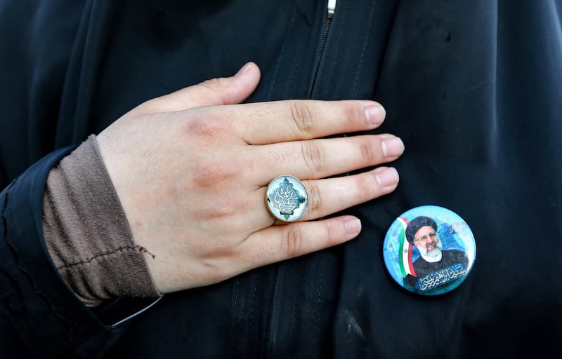 A woman wears a pin bearing the image of Iran's newly elected president Ebrahim Raisi during a rally in Imam Hossein square. AFP