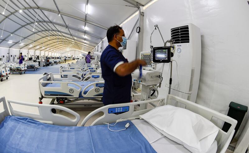 Bahraini health sector experts set up patient monitoring equipment at the Sitra field Intensive Care Unit (ICU) hospital for COVID-19 patients, on May 4, 2020 in Sitra island south of the Bahraini capital Manama. - The hospital, which is attached to a quarantine camp and spread-out over an area of 2400 square meters, is the first field Intensive Care Unit (ICU) to be setup far from a hospital and has its own lab, pharmacy, medical supply store, X-ray machines, and mobile dialysis units. It is run by 55 doctors and 250 nurses. It is the second field hospital out of five planned to add 500 ICU beds to Bahrain's health network. (Photo by Mazen Mahdi / AFP)