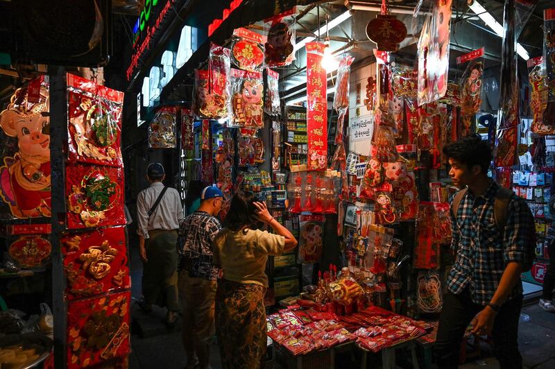 Customers look at decorations at a street market in Yangon's Chinatown district in Myanmar. AFP