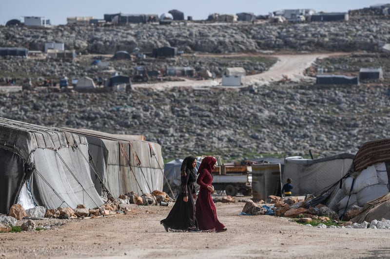 Displaced Syrian women walk at a camp in Kafr Lusin village on the border with Turkey in Syria's northwestern province of Idlib. When protesters in March 2011 demanded their rights and regime change, they likely never imagined it would trigger a reaction that has led to the 21st century's biggest war. Nine years on, President Bashar al-Assad is still in power and there to stay, more than 380,000 people have died, dozens of towns and cities razed to the ground and half of the country's entire population displaced.  AFP