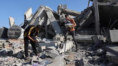 Palestinians collect books from the rubble of a cultural centre following an Israeli strike in Rafah in November. AFP