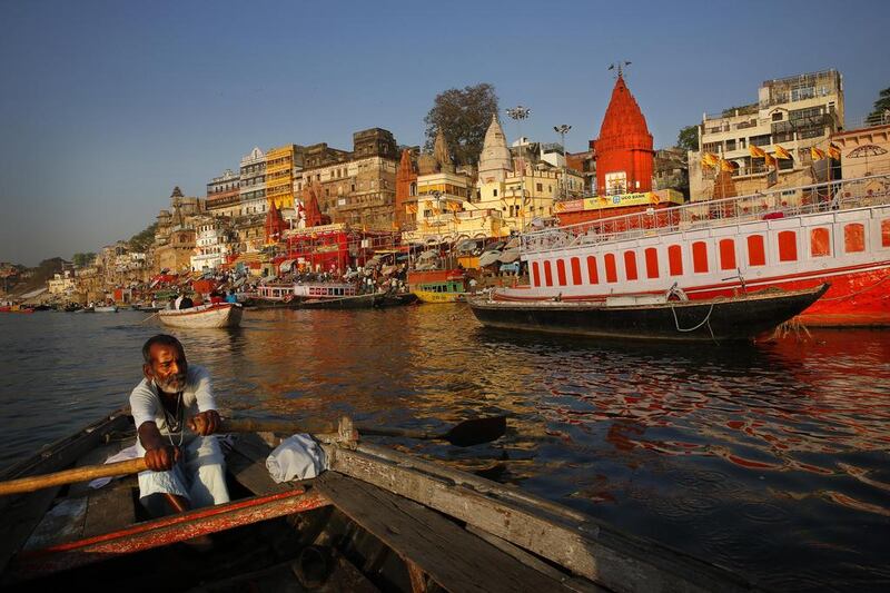 An Indian boatman rows past some of the many ghats that line the banks of the River Ganges in the city of Varanasi. Manish Swarup / AP Photo
