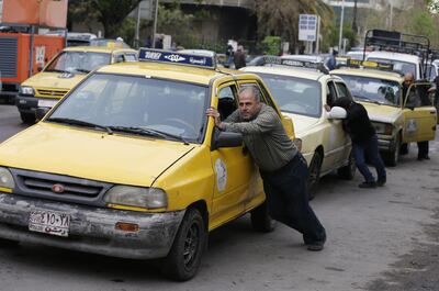 Taxi drivers push their cars that ran out of gasoline to a petrol station in the Syrian capital Damascus on April 16, 2019.  Syria adopted new measures yesterday to curb fuel shortages President Bashar al-Assad's government has blamed on strangling Western sanctions on the war-torn country.
The country's government has faced a barrage of international sanctions since the conflict started in 2011, including measures impacting the import of petroleum-related products. / AFP / LOUAI BESHARA
