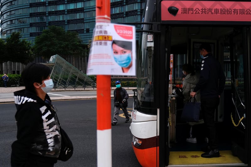 Passengers wear masks at a bus stop in Macau, China. Reuters