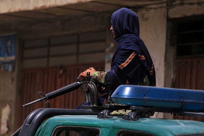 A Taliban stands guard outside a school in the aftermath of multiple bomb blasts, in a Shi'ite majority neighborhood, in Kabul, Afghanistan. EPA