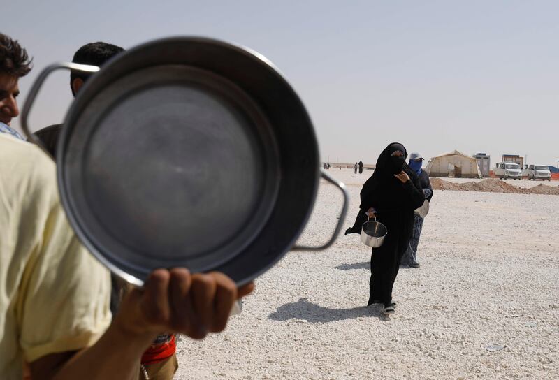 Displaced Syrians queue up to receive food at the Al-Mabrouka camp in the village of Ras al-Ain on the Syria-Turkey border, where many Syrians who fled from territory held by the Islamic State (IS) group in Raqa and Deir Ezzor are taking shelter on August 24, 2017.  / AFP PHOTO / Delil souleiman