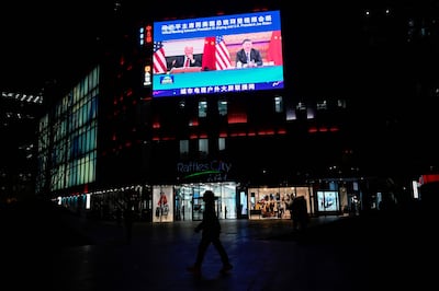 An outdoor screen shows a news program about a virtual meeting between Chinese President Xi Jinping and US President Joe Biden in Beijing on November 16, 2021. AFP