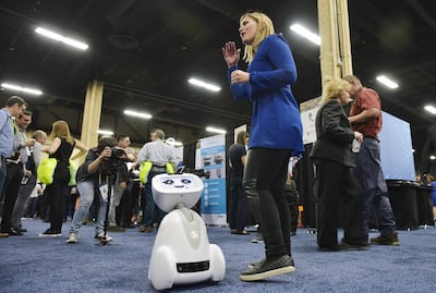 A woman plays with Buddy the companion robot by Blue Frog Robotics is seen on display during the CES Unveiled preview event at the Mandalay Bay Convention Center during CES 2018 in Las Vegas on January 7, 2018.  / AFP PHOTO / MANDEL NGAN