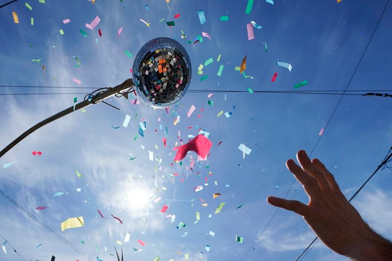 A Societe de Sainte Anne parade visitor throws confetti during Mardi Gras. AP