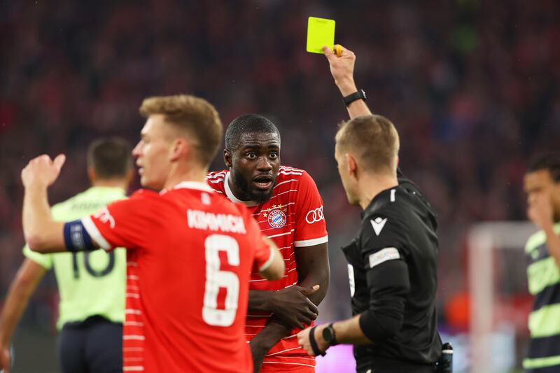 Dayot Upamecano of Bayern Munich is shown a yellow card after a handball that resulted in a penalty for Manchester City. Getty