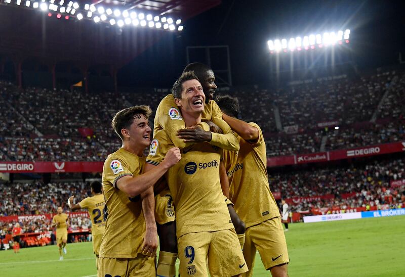 Robert Lewandowski celebrates with Barcelona teammates after scoring against Sevilla. AP