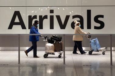 Arriving passengers walk past a sign in the arrivals area at Heathrow Airport in London. AP 