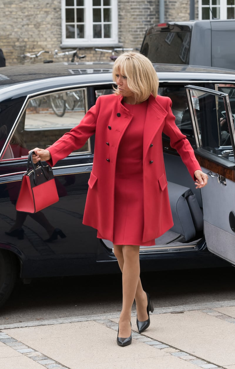 Brigitte, wearing a red dress and coat, and carrying a matching handbag, visits Denmark on August 28, 2018. AFP 