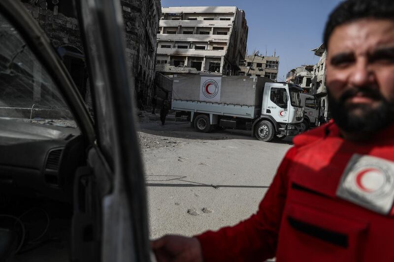 Volunteers with Syrian Arab Red Crescent (SARC) unload aid trucks in Douma, in Eastern Ghouta, Syria, on March 5, 2018. Mohammed Badra / EPA