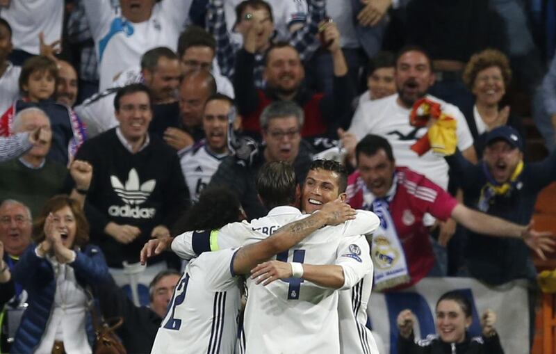 Cristiano Ronaldo, right, is hugged by teammates after scoring. Francisco Seco / AP Photo