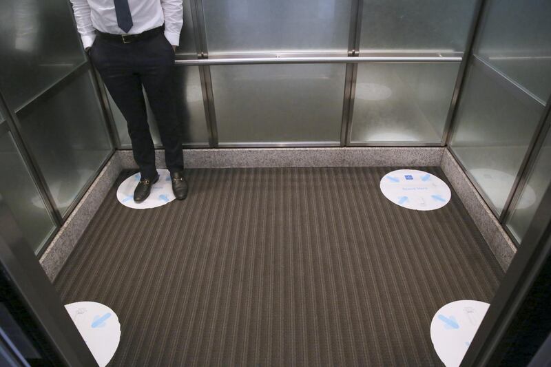 An employee stands on a social distancing marker in an elevator at a JLL office in Dallas, Texas, U.S. Constraints such as social distancing and masks mean the precise nature of the future office working environment remains an open question even as some signs of normality return with some workers returning to their desks. Bloomberg