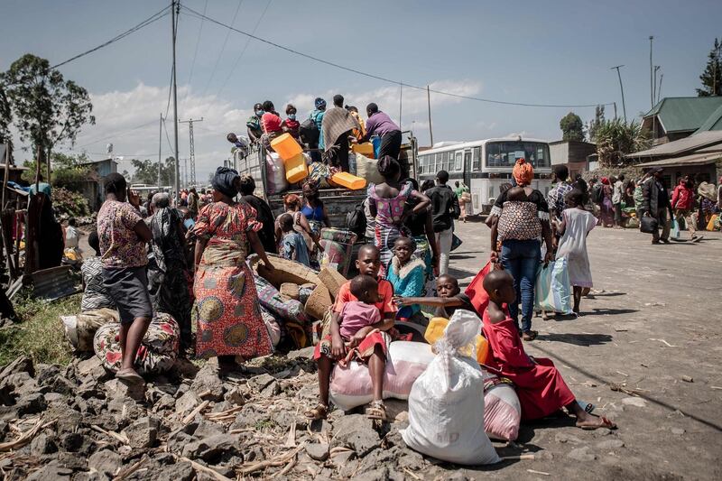 People aboard a truck in Sake with their belongings, waiting to be taken to home.