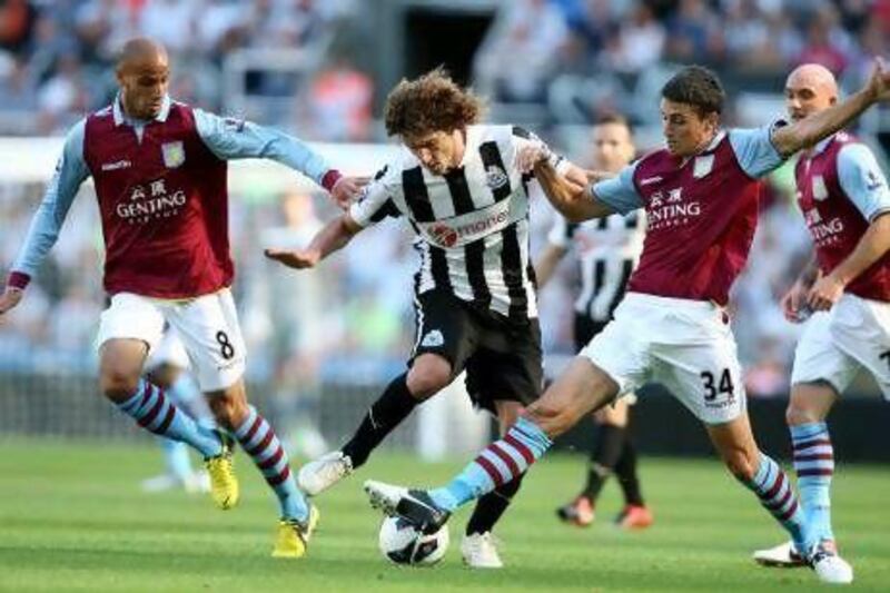 Newcastle United's captain Fabricio Coloccini, center, vies for the ball with Aston Villa's Matthew Lowton, right, and Karim El Ahmadi, left, during their English Premier League soccer match at the Sports Direct Arena, Newcastle, England, Sunday, Sept. 2, 2012. (AP Photo/Scott Heppell) *** Local Caption *** Britain Soccer Premier League.JPEG-0e2f2.jpg
