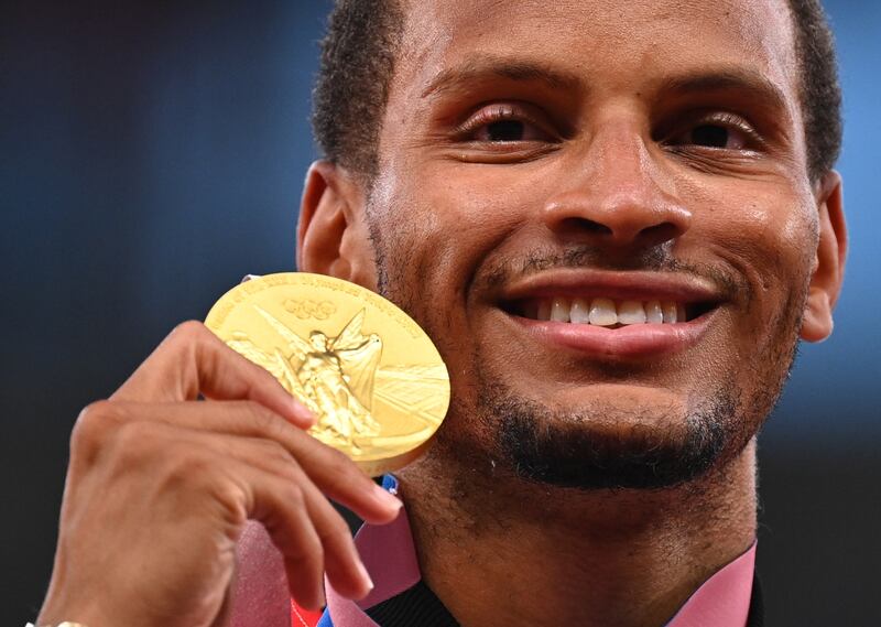 Gold medallist in the men's 200m final, Andre De Grasse of Canada, poses as he celebrates on the podium REUTERS / Dylan Martinez