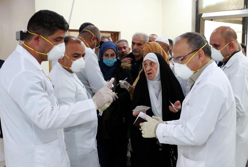 epa08244101 Members of Iraqi medical team check passengers upon arrival from Iran at Baghdad international airport in Baghdad, Iraq, 24 February 2020. According to reports, Iraqi health authorities said on 24 February that an Iranian national in the city of Najaf tested positive for the coronavirus, becoming the first confirmed case of the COVID-19 disease in the country. Iraqi authorities have taken action to screen those arriving at the airports and border crossings with Iran, while the Iraqi airlines canceled all flights to Iran, following the cases of the deadly Covid-19 Coronavirus diagnosed in Iran.  EPA/AHMED JALIL