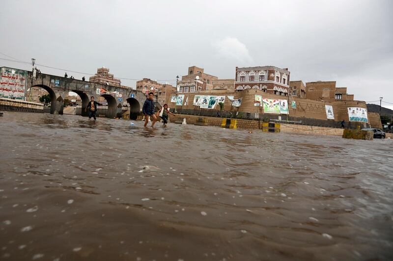 Yemeni children walk through a flooded street following heavy rains in the old quarter of Sana'a, Yemen.  EPA